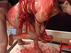 The redhead babe endures hot wax in bondage.