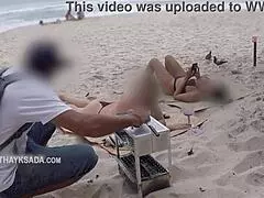 Hot wife begs vendor for sunscreen at beach. Her curves shine under the sun.