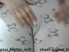 mature woman in pajamas masturbates with vibrator, showing wet cameltoe and big natural tits