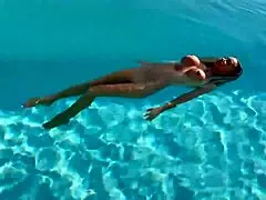 Monika Fox swims naked in the pool, her big tits exposed