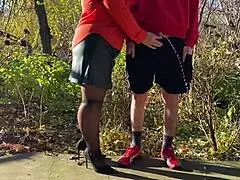Mother-in-law assists with outdoor urination in public, wearing pantyhose and heels.