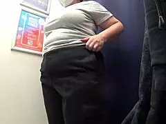 This curvy milf in the fitting room has a big ass in satin panties as she changes clothes.
