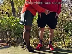 Mother-in-law assists with outdoor urination in public, wearing pantyhose and heels.