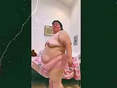 mature old cougar performs topless dance in front of webcam, showcasing natural saggy tits