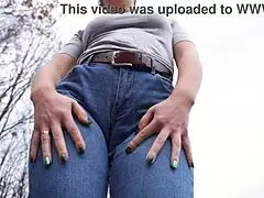 Milf teasing her big cameltoe in blue jeans outdoors