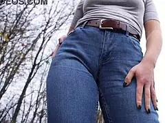Milf teasing her big cameltoe in blue jeans outdoors