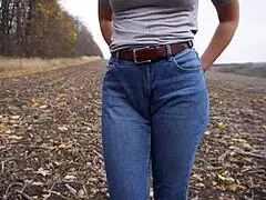 Milf teasing her big cameltoe in blue jeans outdoors