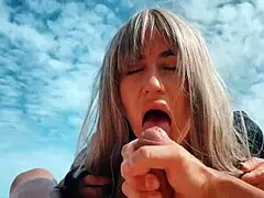 blonde milf masturbates on the nudist beach, stroking a guy's dick with her feet.