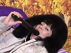 Milf sucks big dildo in fur-trimmed coat