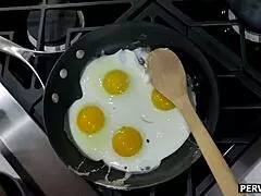 Stepmom deepthroats cock while cooking breakfast in kitchen.