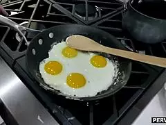 Stepmom deepthroats cock while cooking breakfast in kitchen.