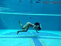 In the pool, a Hungarian woman plays naked sazan cheharda, swimming and teasing underwater with playful moves.