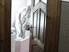 Naked blonde in bathroom, roommate watches and cums on her wet pussy?