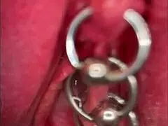 close up on shaved pussy lips and pierced clit as she pisses outdoors