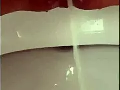 close up on shaved pussy lips and pierced clit as she pisses outdoors