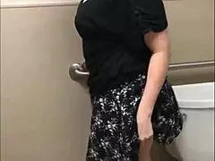 Pretty babe shows off her ass while peeing in the bathroom