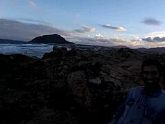 Young girl blows rocks by sea